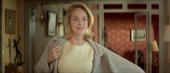 Movie still from “Le Dîner de Cons” (1998), directed by Francis Veber – A beautiful blonde woman holding onto a jacket; Medium shot, Over the shoulder angle