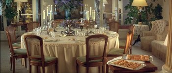 Movie still from “Le Dîner de Cons” (1998), directed by Francis Veber – A dining room table set for a meal with candles; Wide shot, High angle