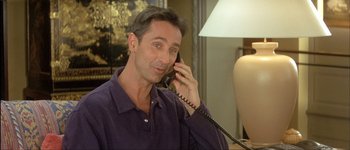 Movie still from “Le Dîner de Cons” (1998), directed by Francis Veber – A person talking on a phone; Medium shot, Low angle