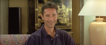 Movie still from “Le Dîner de Cons” (1998), directed by Francis Veber – A man in a purple shirt smiling for the camera; Close Up shot, Low angle