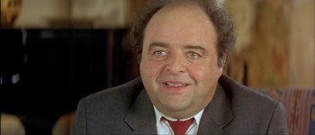 Movie still from “Le Dîner de Cons” (1998), directed by Francis Veber – A person wearing a suit and tie; Close Up shot, High angle