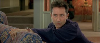 Movie still from “Le Dîner de Cons” (1998), directed by Francis Veber – A person sitting on a couch; Close Up shot, High angle