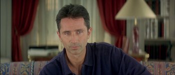 Movie still from “Le Dîner de Cons” (1998), directed by Francis Veber – A person wearing a blue shirt; Close Up shot, Over the shoulder angle
