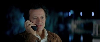 Movie still from “Le Dîner de Cons” (1998), directed by Francis Veber – A person talking on a cell phone; Close Up shot, Low angle