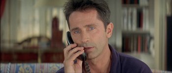 Movie still from “Le Dîner de Cons” (1998), directed by Francis Veber – A person talking on a cell phone; Close Up shot, Low angle