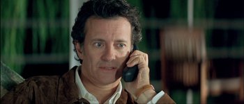 Movie still from “Le Dîner de Cons” (1998), directed by Francis Veber – A person talking on a cell phone; Close Up shot, High angle