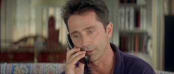 Movie still from “Le Dîner de Cons” (1998), directed by Francis Veber – A person talking on a phone; Close Up shot, High angle