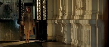 Movie still from “Le Dîner de Cons” (1998), directed by Francis Veber – A building with a metal door and a metal gate; Wide shot, Low angle