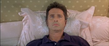 Movie still from “Le Dîner de Cons” (1998), directed by Francis Veber – A person laying in a bed; Close Up shot, Overhead angle