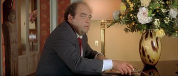 Movie still from “Le Dîner de Cons” (1998), directed by Francis Veber – A man sitting at a table in front of a lamp; Close Up shot, Low angle