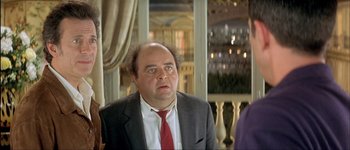 Movie still from “Le Dîner de Cons” (1998), directed by Francis Veber – A man in a suit and red neck tie; Close Up shot, Over the shoulder angle