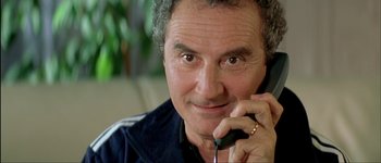 Movie still from “Le Dîner de Cons” (1998), directed by Francis Veber – A person talking on a cell phone; Close Up shot, Low angle