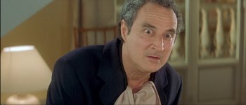 Movie still from “Le Dîner de Cons” (1998), directed by Francis Veber – An older man with a surprised look on his face; Close Up shot, Low angle