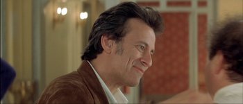 Movie still from “Le Dîner de Cons” (1998), directed by Francis Veber – A person wearing a brown jacket; Close Up shot, Low angle