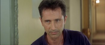 Movie still from “Le Dîner de Cons” (1998), directed by Francis Veber – A person wearing a purple shirt; Close Up shot, Low angle