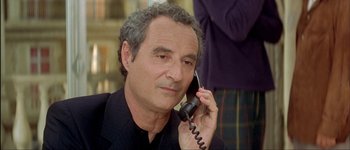 Movie still from “Le Dîner de Cons” (1998), directed by Francis Veber – A person talking on a phone; Close Up shot, Over the shoulder angle