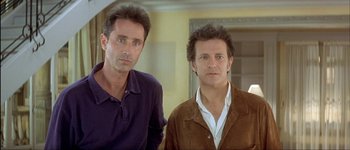 Movie still from “Le Dîner de Cons” (1998), directed by Francis Veber – A couple of men standing next to each other; Close Up shot, Low angle