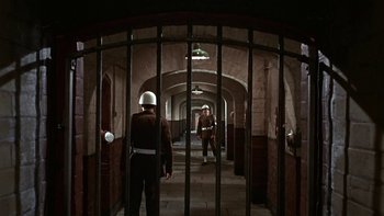 Movie still from “The Dirty Dozen” (1967), directed by Robert Aldrich – Two men in uniform are standing in a tunnel; Wide shot, High angle
