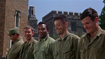 Movie still from “The Dirty Dozen” (1967), directed by Robert Aldrich – A group of men standing next to each other in front of a building; Medium shot, Low angle