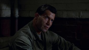 Movie still from “The Dirty Dozen” (1967), directed by Robert Aldrich – A person sitting in front of a brick wall; Close Up shot, High angle