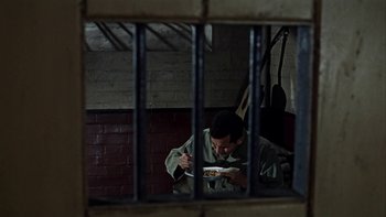 Movie still from “The Dirty Dozen” (1967), directed by Robert Aldrich – A man eating a sandwich in a jail cell; Medium shot, High angle