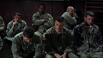 Movie still from “The Dirty Dozen” (1967), directed by Robert Aldrich – A group of men sitting next to each other in a room; Medium shot, High angle