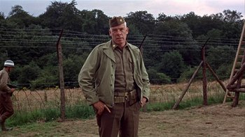 Movie still from “The Dirty Dozen” (1967), directed by Robert Aldrich – An older man in a uniform standing in a field; Medium shot, Low angle