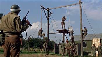 Movie still from “The Dirty Dozen” (1967), directed by Robert Aldrich – A group of men hanging from a wooden structure; Wide shot, Low angle