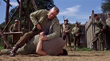 Movie still from “The Dirty Dozen” (1967), directed by Robert Aldrich – Two men are wrestling on the ground in a field; Medium shot, Over the shoulder angle
