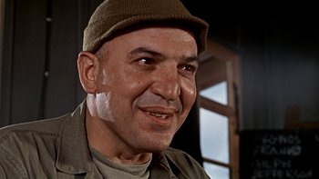 Movie still from “The Dirty Dozen” (1967), directed by Robert Aldrich – An older man wearing a hat and smiling for the camera; Close Up shot, Low angle