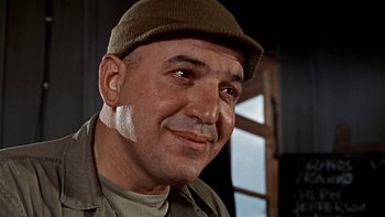 Movie still from “The Dirty Dozen” (1967), directed by Robert Aldrich – An older man wearing a hat and smiling for the camera; Close Up shot, Low angle