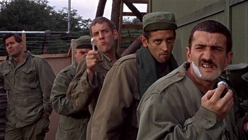 Movie still from “The Dirty Dozen” (1967), directed by Robert Aldrich – A group of men standing next to each other on a field; Medium shot, Over the shoulder angle