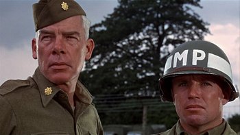 Movie still from “The Dirty Dozen” (1967), directed by Robert Aldrich – Two men in military uniforms are posing for a picture; Close Up shot, Low angle