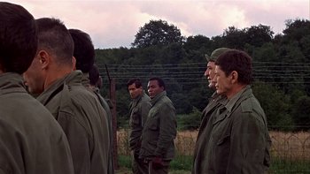Movie still from “The Dirty Dozen” (1967), directed by Robert Aldrich – A group of men standing next to each other in a field; Medium shot, Over the shoulder angle