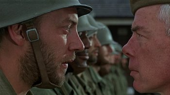 Movie still from “The Dirty Dozen” (1967), directed by Robert Aldrich – A group of men in uniforms are standing in a row; Close Up shot, Over the shoulder angle