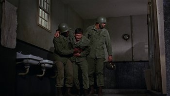 Movie still from “The Dirty Dozen” (1967), directed by Robert Aldrich – A group of men standing next to each other in a room; Wide shot, High angle