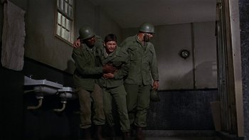 Movie still from “The Dirty Dozen” (1967), directed by Robert Aldrich – A group of men standing next to each other in a room; Wide shot, High angle