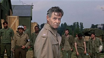 Movie still from “The Dirty Dozen” (1967), directed by Robert Aldrich – A group of men standing next to each other in a field; Medium shot, Over the shoulder angle