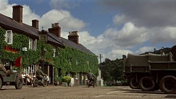 Movie still from “The Dirty Dozen” (1967), directed by Robert Aldrich – An army vehicle parked in front of a building; Wide shot, Low angle