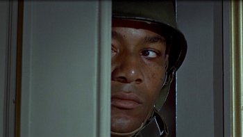 Movie still from “The Dirty Dozen” (1967), directed by Robert Aldrich – A man wearing a helmet looking out a window; Close Up shot, Low angle