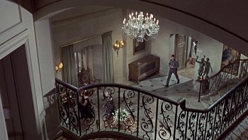 Movie still from “The Dirty Dozen” (1967), directed by Robert Aldrich – A view from above of a room with a chandelier and a staircase; Extreme Wide shot, High angle