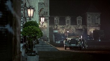 Movie still from “The Dirty Dozen” (1967), directed by Robert Aldrich – A group of cars parked in front of a building at night; Extreme Wide shot, High angle