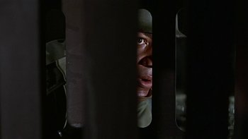 Movie still from “The Dirty Dozen” (1967), directed by Robert Aldrich – A person looking through a fence; Close Up shot, Low angle