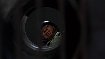 Movie still from “The Dirty Dozen” (1967), directed by Robert Aldrich – A man wearing a helmet looking through a hole in the wall; Close Up shot, Low angle