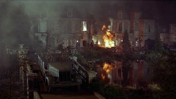 Movie still from “The Dirty Dozen” (1967), directed by Robert Aldrich – A large building on fire in a city at night; Extreme Wide shot, High angle