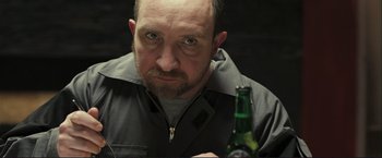 Movie still from “The Disappearance of Alice Creed” (2009), directed by J Blakeson – A person holding a bottle of beer; Close Up shot, Over the shoulder angle