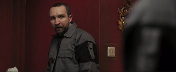 Movie still from “The Disappearance of Alice Creed” (2009), directed by J Blakeson – A man standing in front of a red wall; Medium shot, Low angle