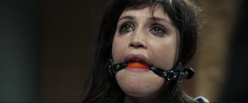 Movie still from “The Disappearance of Alice Creed” (2009), directed by J Blakeson – A woman with a carrot in her mouth; Close Up shot, High angle