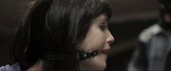 Movie still from “The Disappearance of Alice Creed” (2009), directed by J Blakeson – A woman with a leather collar around her neck; Extreme Close Up shot, Over the shoulder angle