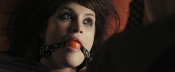 Movie still from “The Disappearance of Alice Creed” (2009), directed by J Blakeson – A woman with a gag around her mouth and a tomato in her mouth; Close Up shot, High angle